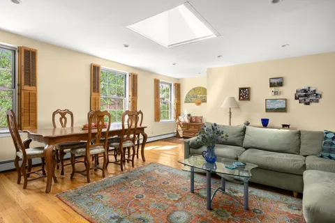 a living room with furniture kitchen view and a large window