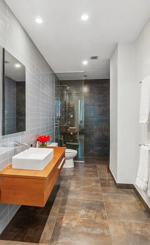 420 West 25th Street, Unit TH1E Manhattan, NY 10001 - Photo 14 of 22 a bathroom with a tub sink shower and a mirror