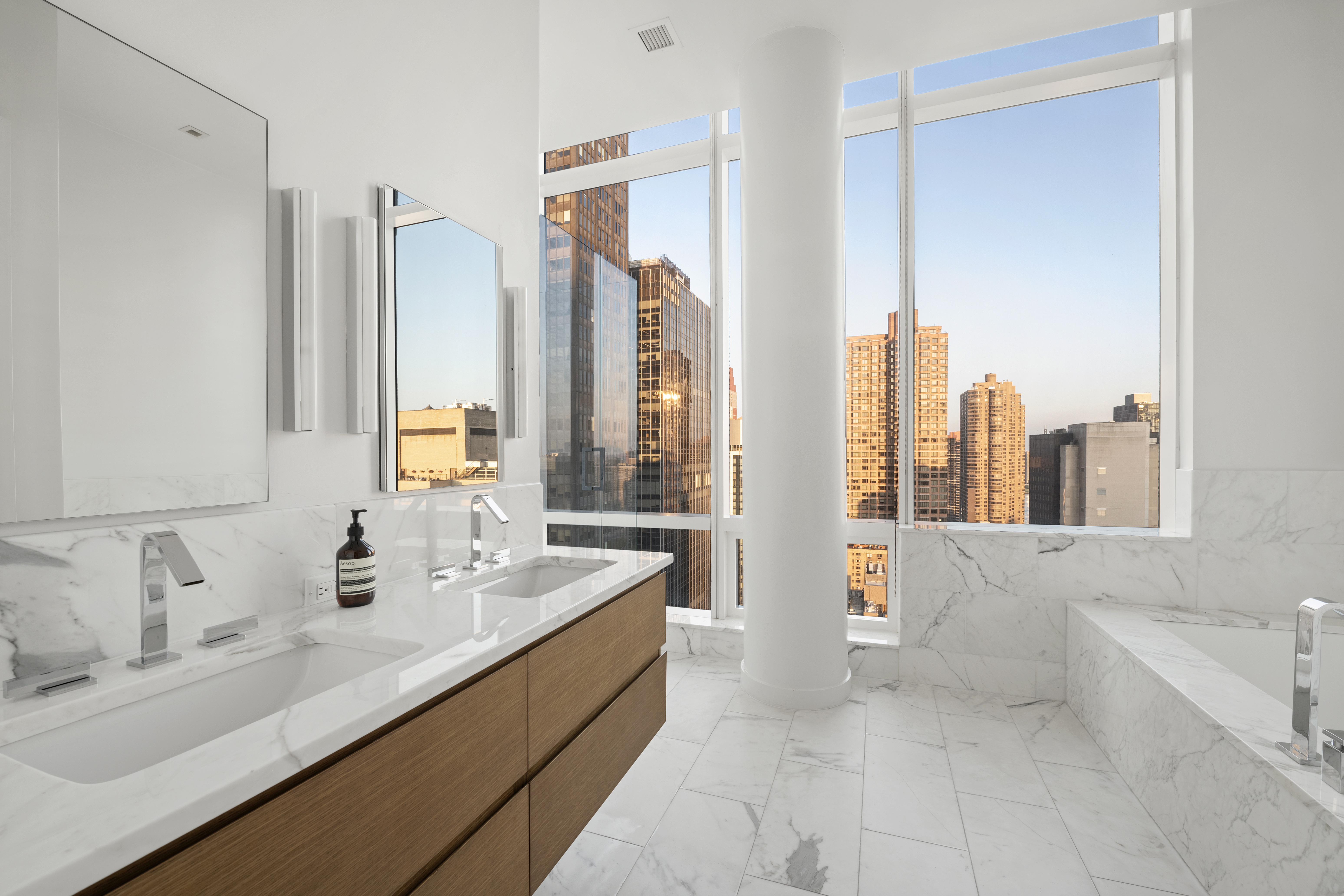325 Lexington Avenue, Unit PHB Manhattan, NY 10016 - Photo 10 of 20 a bathroom with a double vanity sink a mirror and a bathtub