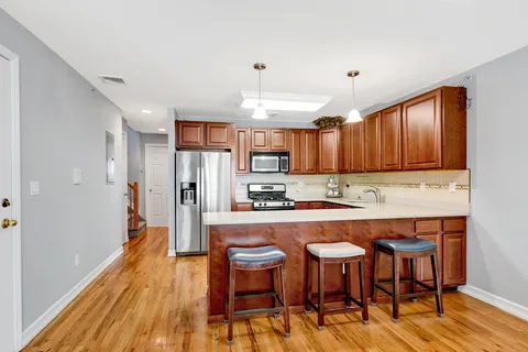 a kitchen with a table chairs refrigerator and wooden cabinets