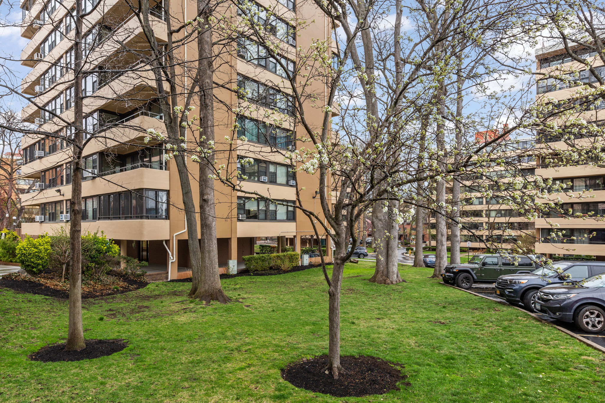 11-01 162nd Street, Unit 3D Queens, NY 11357 - Photo 12 of 16 a front view of a building with a garden