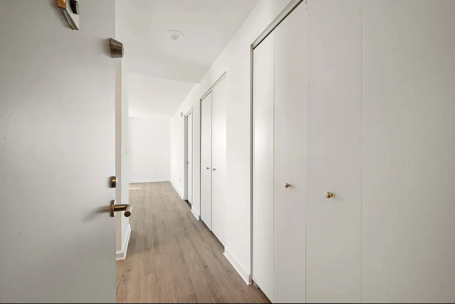 a view of a room with wooden floor and white walls