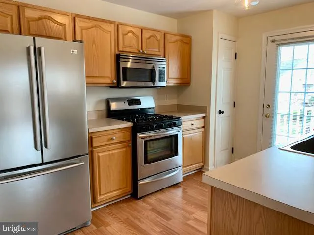 a kitchen with stainless steel appliances a refrigerator stove and microwave