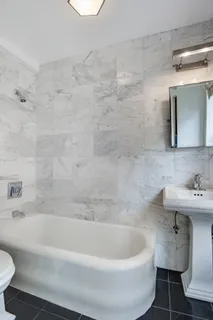 a white bath tub sitting next to a white toilet