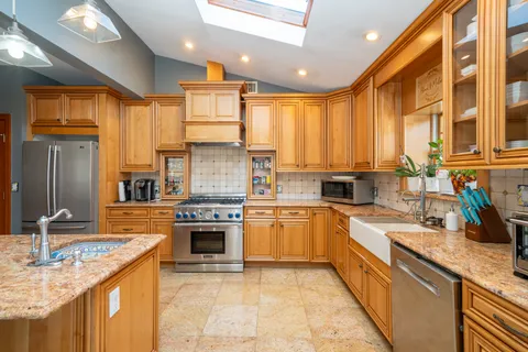 a kitchen with stainless steel appliances granite countertop a sink stove and refrigerator