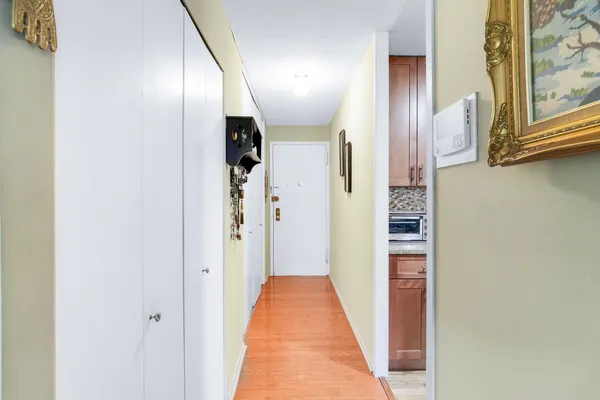 a view of a hallway with wooden floor and staircase
