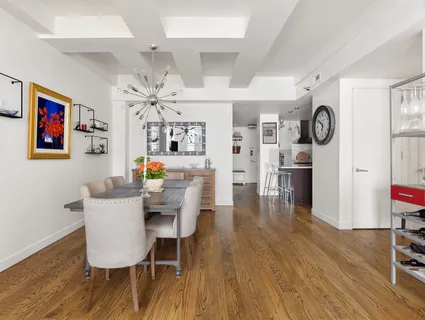 a view of a dining room with furniture wooden floor and a clock