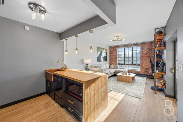 a view of a kitchen area with furniture and wooden floor
