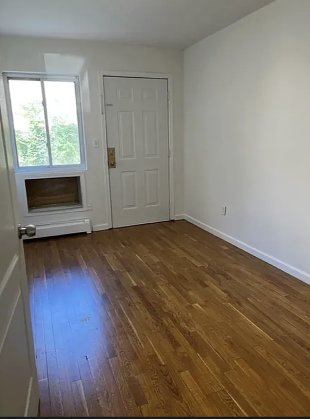 14 East 29th Street Brooklyn, NY 11226 - Photo 4 of 6 an empty room with wooden floor and windows
