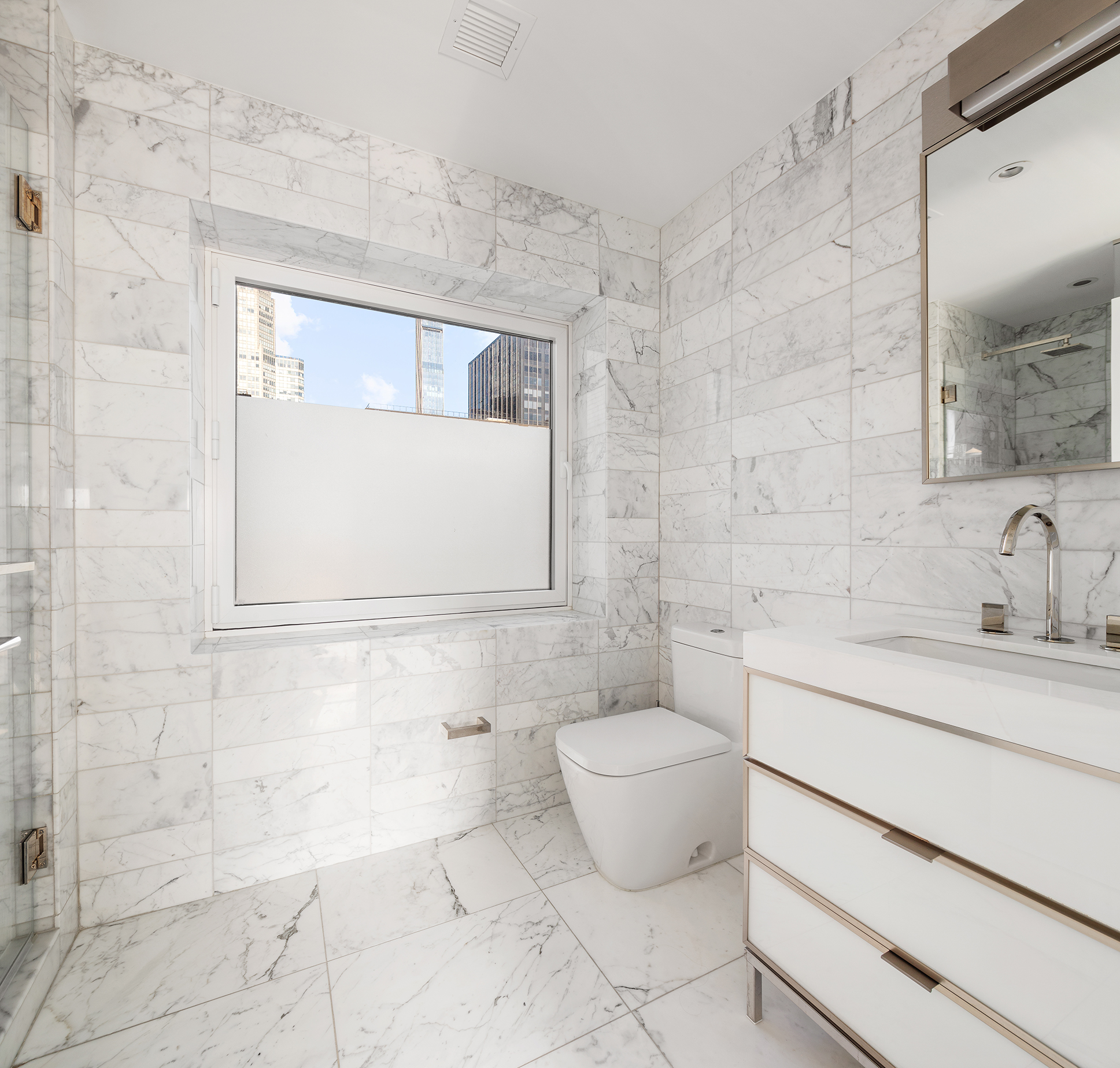 135 West 52nd Street, Unit PH3 Manhattan, NY 10019 - Photo 14 of 17 a bathroom with a granite countertop sink a toilet and mirror