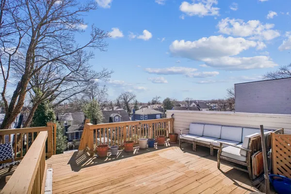a view of a roof deck with couches and wooden floor