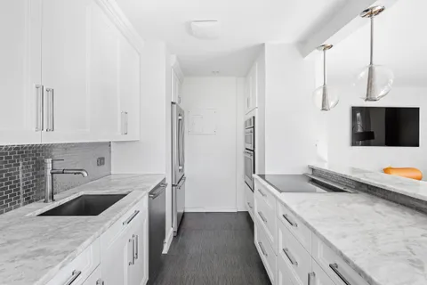 a kitchen with stainless steel appliances granite countertop a sink and a stove