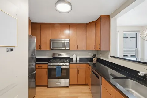 a kitchen with a sink a stove and cabinets