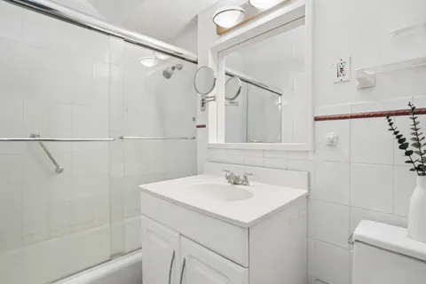 a bathroom with a sink and mirror with toilet