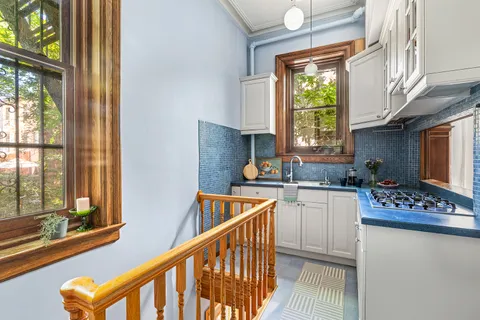 a kitchen that has a sink a stove and chair