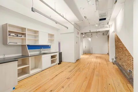 a open kitchen with a white stove top oven and wooden floor