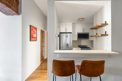 a view of a kitchen with furniture and wooden floor