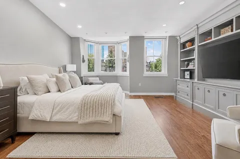 a spacious bedroom with a large bed and a flat screen tv