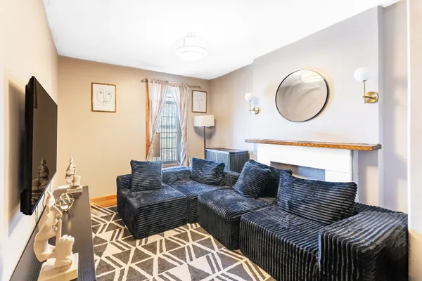 a living room with furniture a flat screen tv and a large window