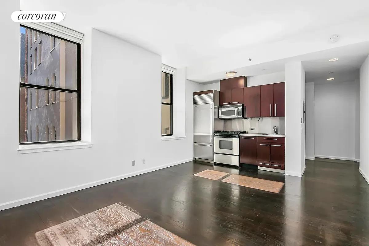150 Nassau Street, Unit 8K Manhattan, NY 10038 - Photo 7 of 8 a view of kitchen with stainless steel appliances cabinets and wooden floor