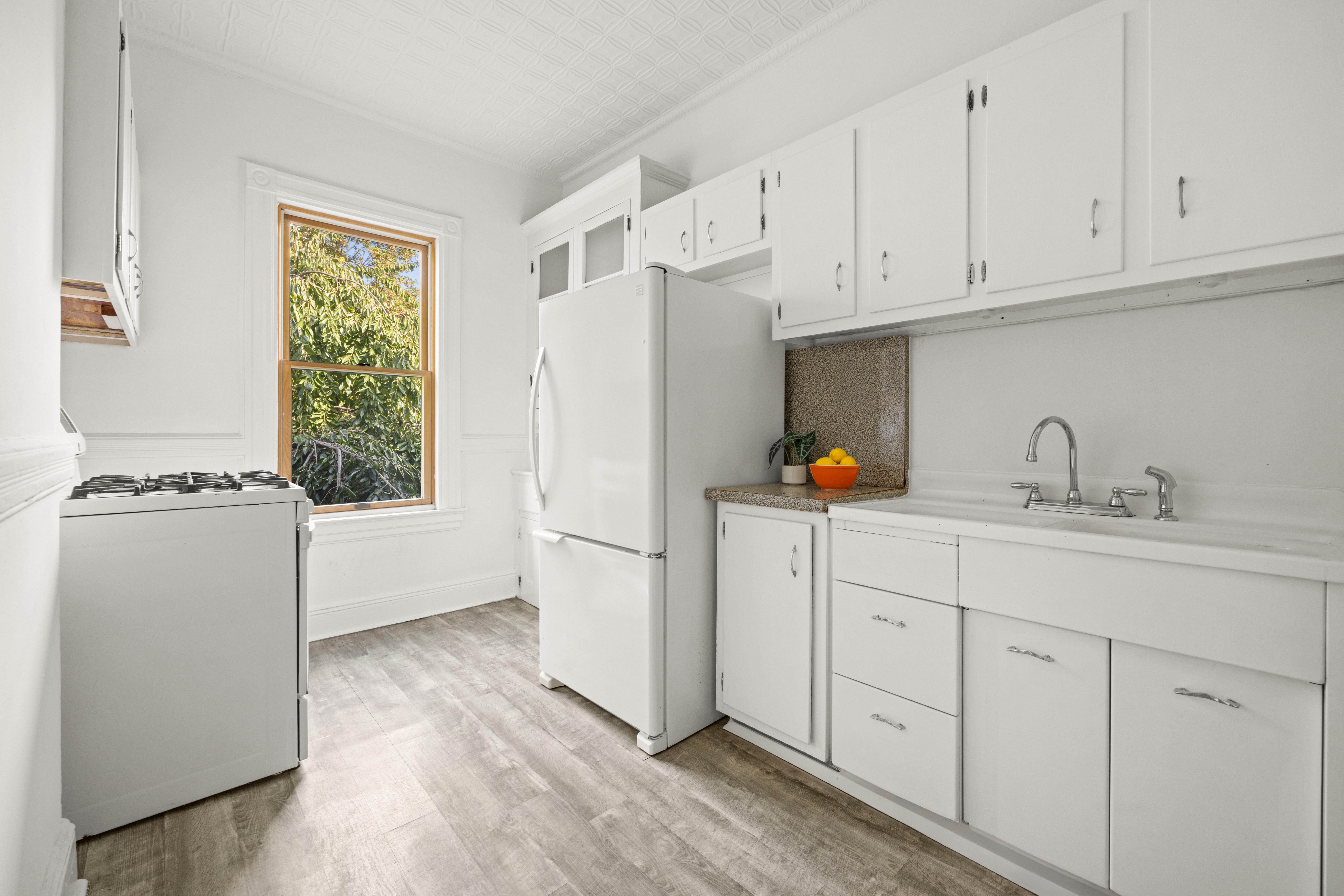 99 East 2nd Street Brooklyn, NY 11218 - Photo 17 of 24 a kitchen with stainless steel appliances white cabinets and a refrigerator