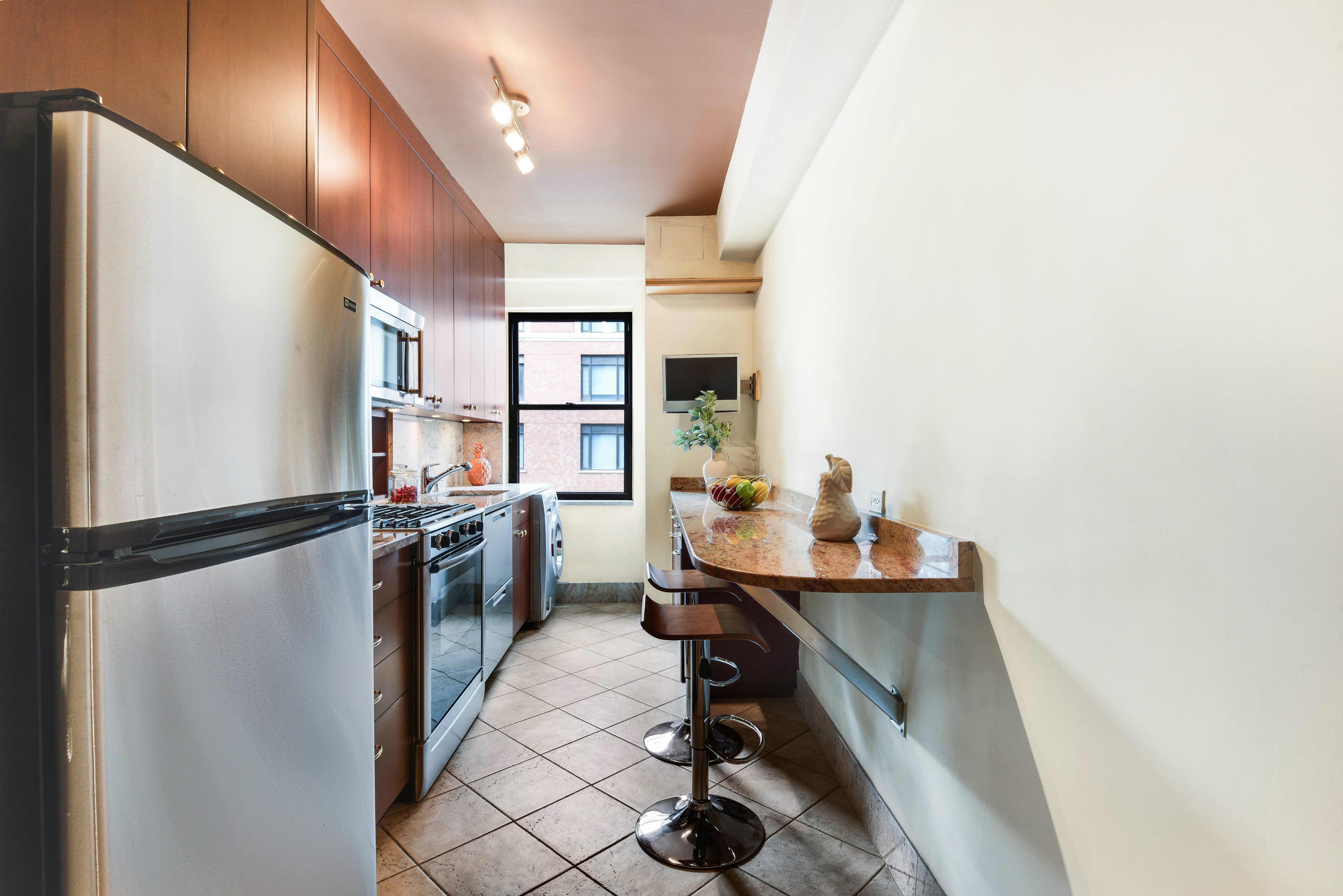 49 East 96th Street, Unit 8/9E Manhattan, NY 10128 - Photo 6 of 17 a kitchen with refrigerator and window