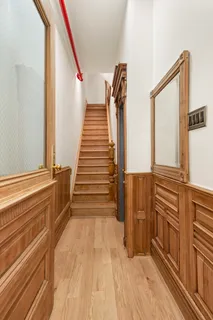 a view of a hallway with stairs and a wooden floor