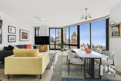 a living room with furniture a flat screen tv and a large window