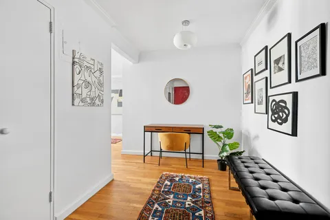 a hallway with wooden floor and white walls