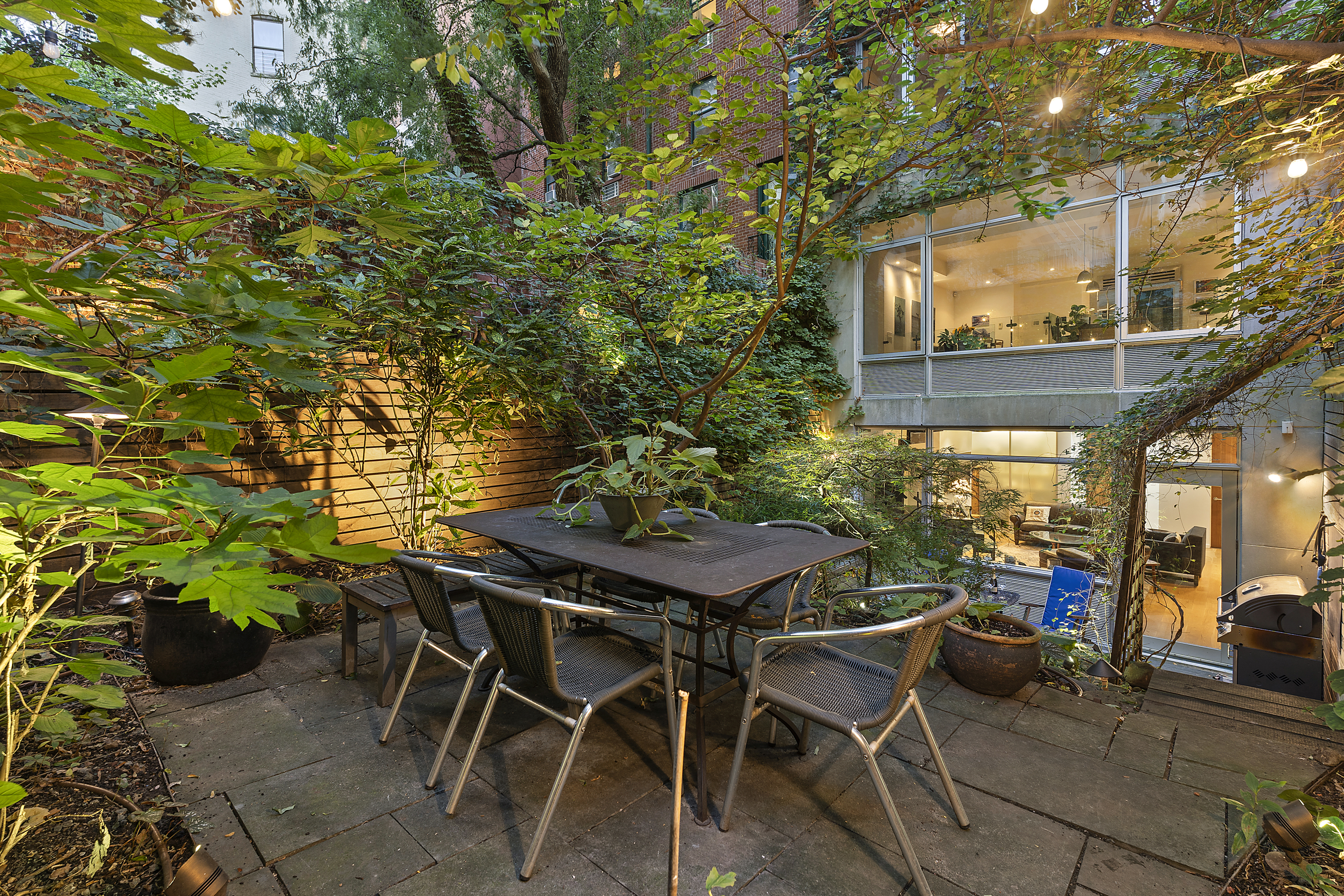 271 West 122nd Street, Unit A Manhattan, NY 10027 - Photo 1 of 19 a view of a patio with table and chairs and potted plants
