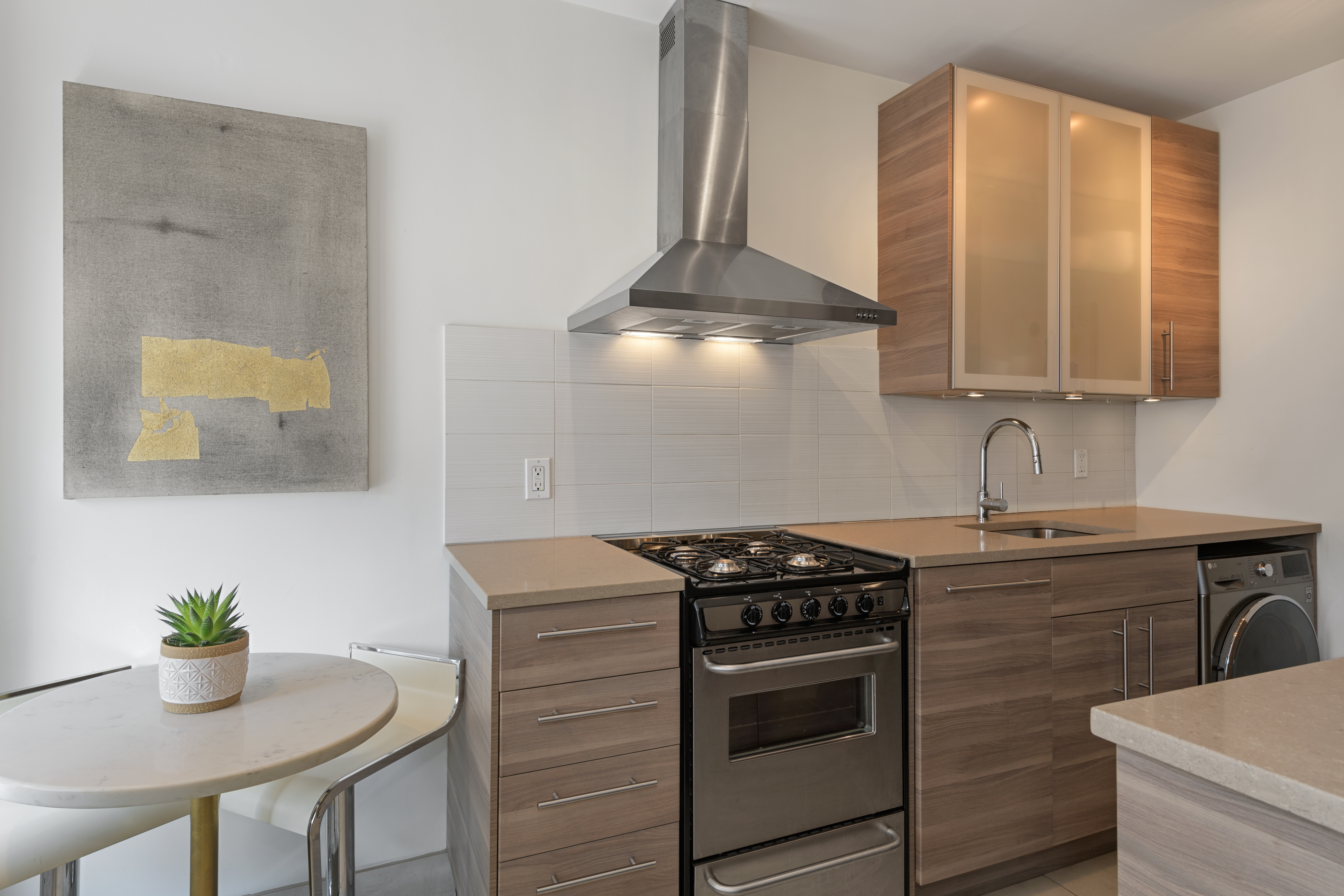 24 Greenwich Avenue, Unit 2 Manhattan, NY 10011 - Photo 3 of 6 a kitchen with stainless steel appliances a stove a chimney a sink and cabinets
