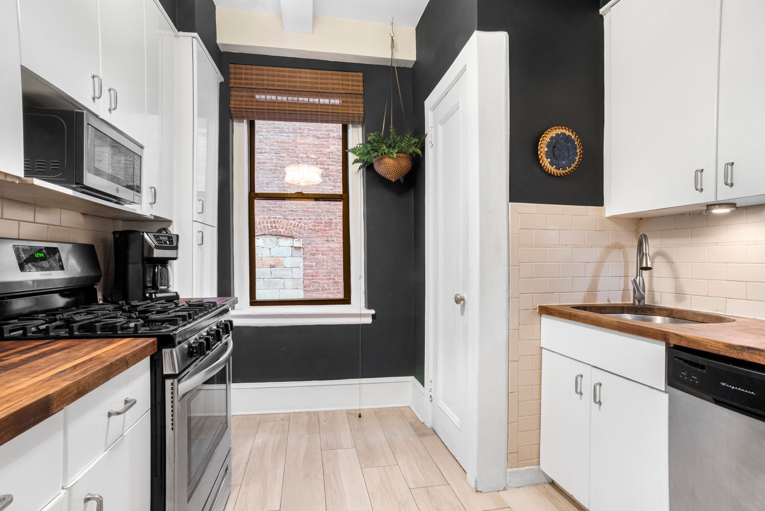114 West 70th Street, Unit 3D Manhattan, NY 10023 - Photo 3 of 9 a kitchen with stainless steel appliances granite countertop a sink and a stove