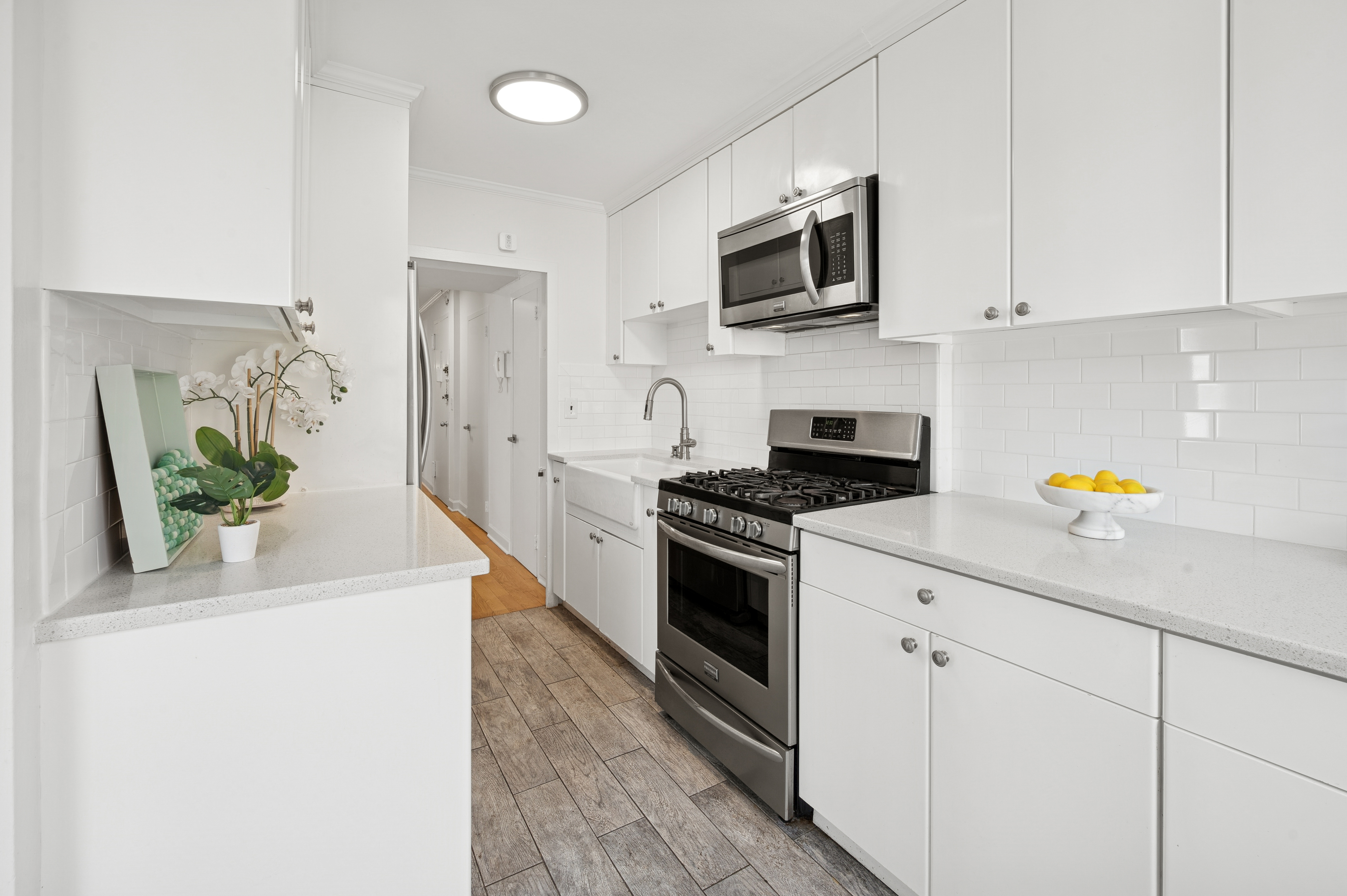 70 La Salle Street, Unit 8C Manhattan, NY 10027 - Photo 9 of 18 a kitchen with stainless steel appliances a stove a microwave a sink and white cabinets