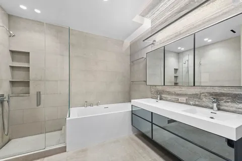 a bathroom with a bathtub shower sink and mirror