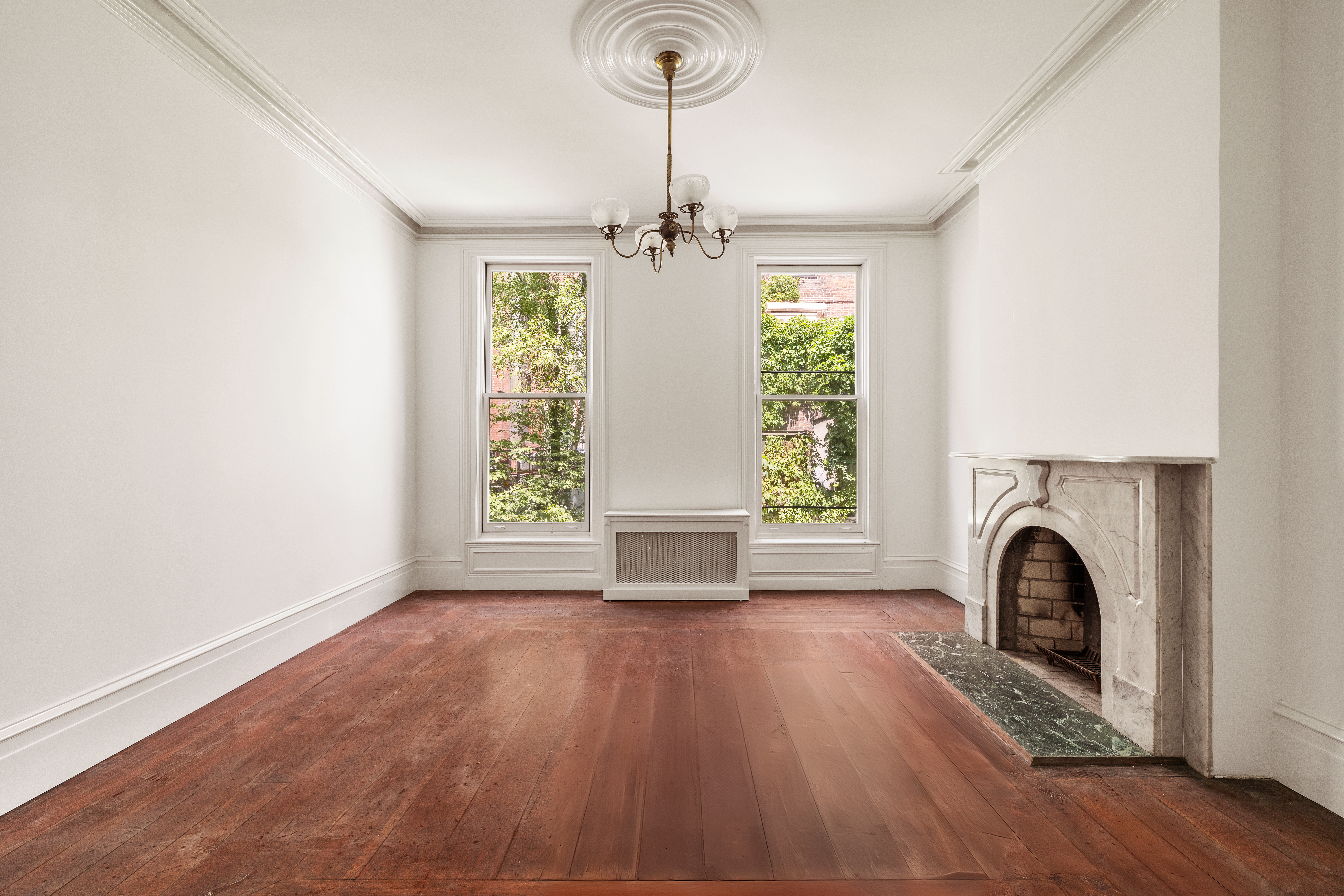 225 West 22nd Street Manhattan, NY 10011 - Photo 5 of 12 a view of a livingroom with a fireplace wooden floor and windows