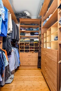 a view of walk in closet with clothes and shoes