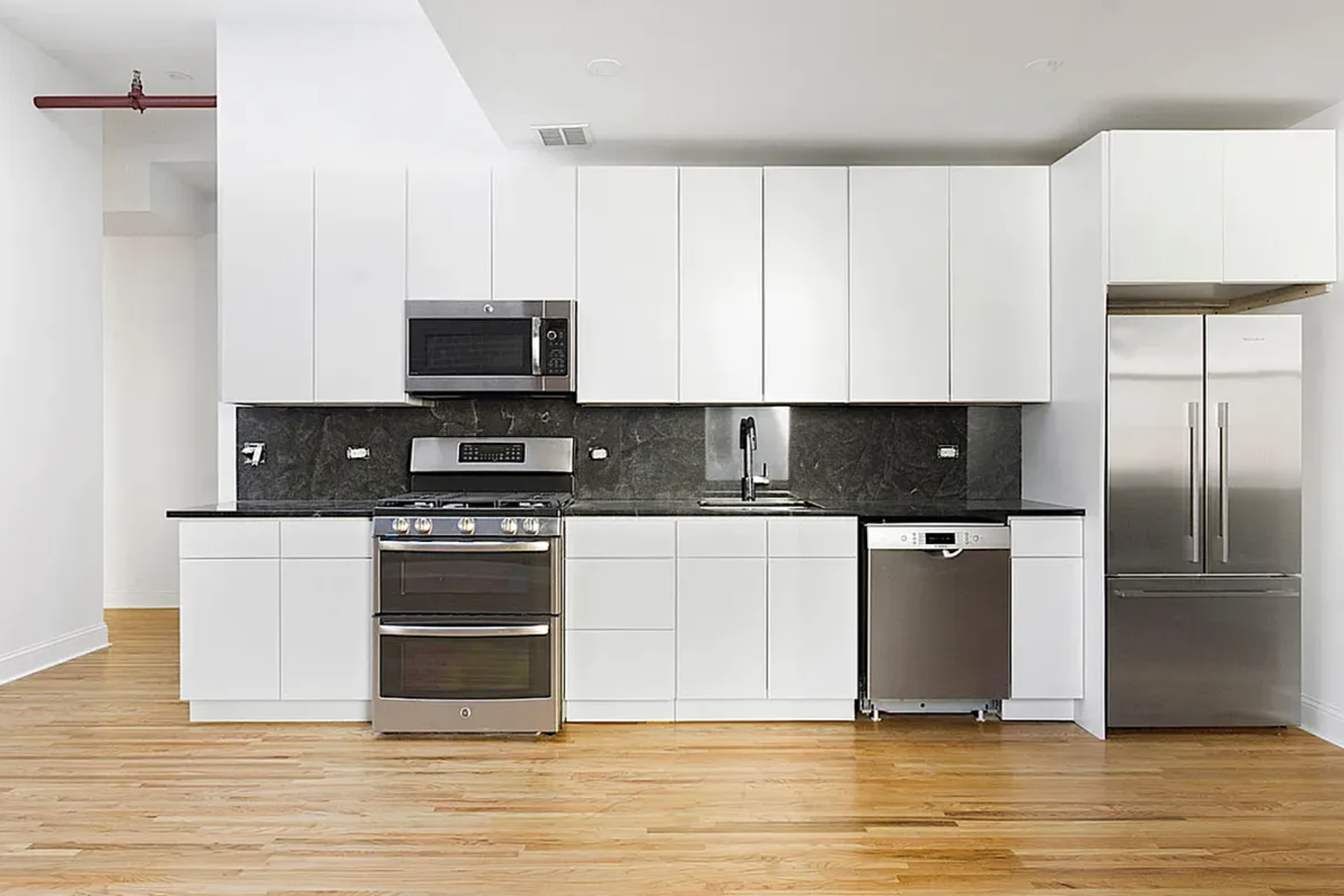 281 Grand Street, Unit 2R Manhattan, NY 10002 - Photo 3 of 5 a kitchen with stainless steel appliances granite countertop a stove a sink and a refrigerator