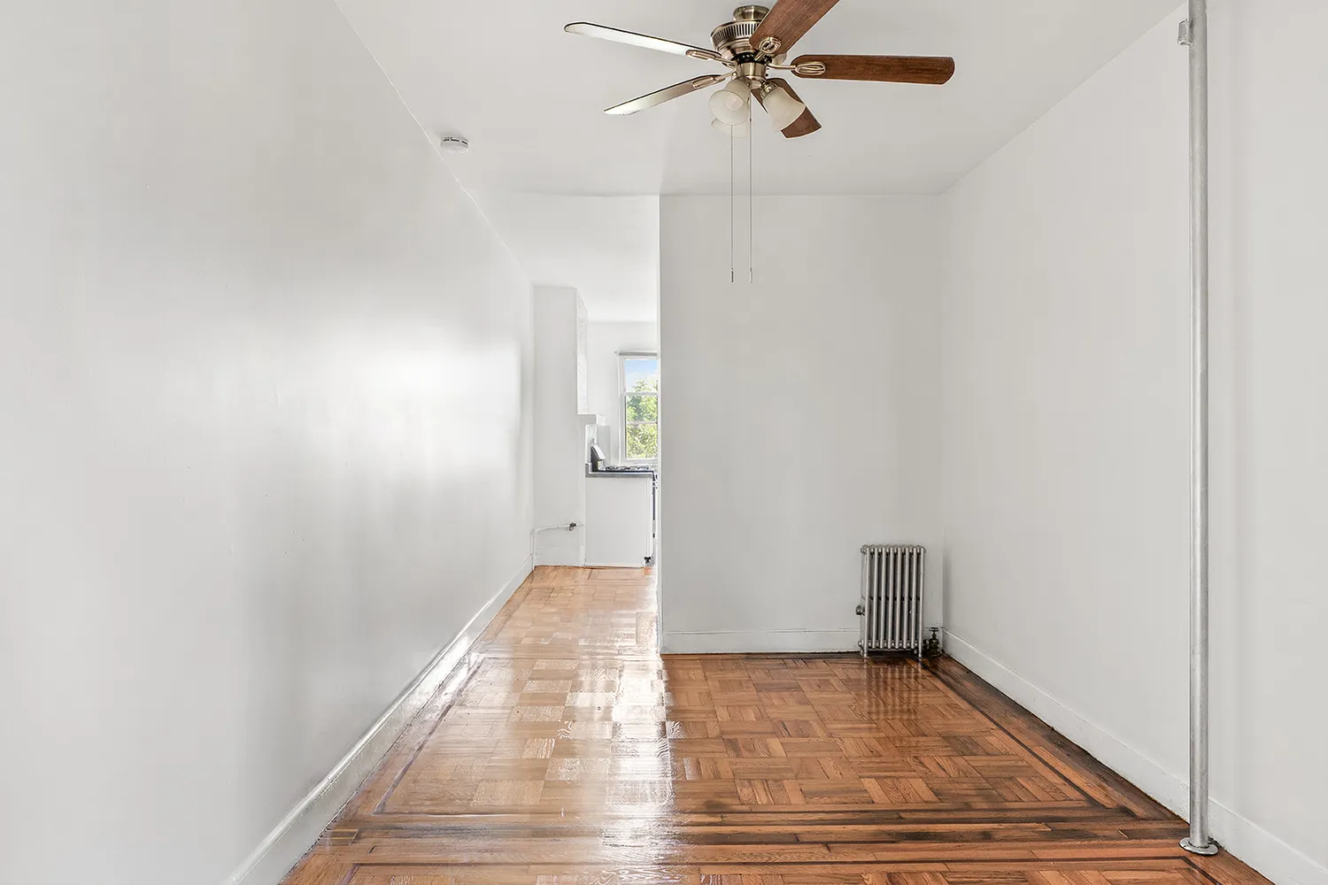 a view of an empty room and wooden floor