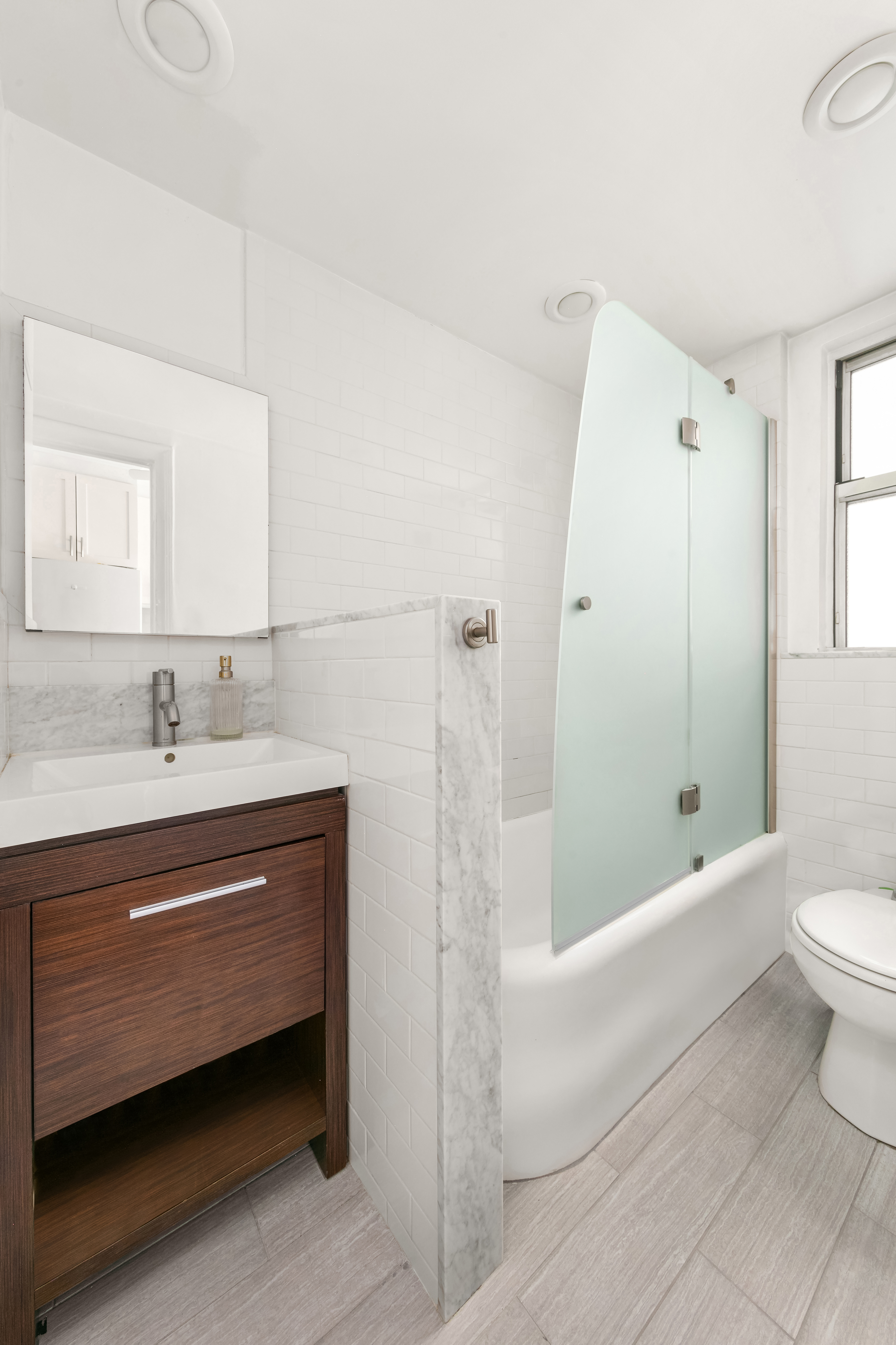 333 East 43rd Street, Unit 311 Manhattan, NY 10017 - Photo 7 of 18 a bathroom with a bathtub shower sink and toilet