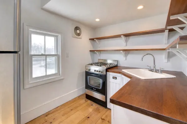 a kitchen with a stove a sink and a window