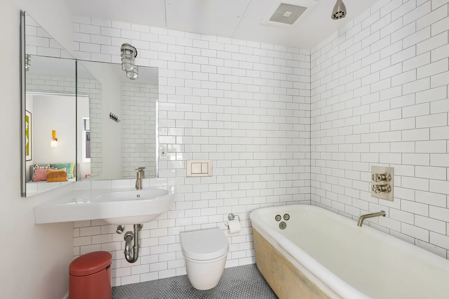 a white bath tub sitting next to a white sink and vanity
