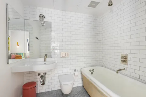 a white bath tub sitting next to a white sink and vanity
