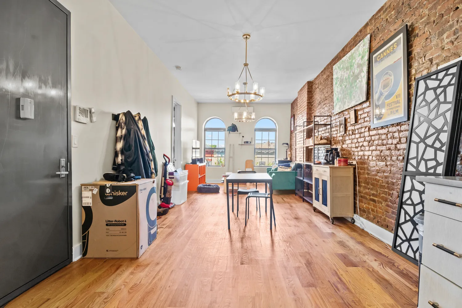 a view of a dining room and livingroom with furniture wooden floor a chandelier