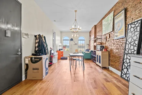 a view of a dining room and livingroom with furniture wooden floor a chandelier
