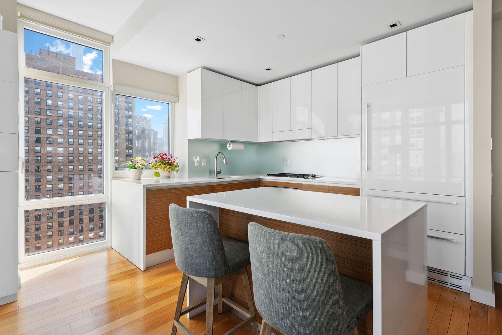 555 West 59th Street, Unit 25E Manhattan, NY 10019 - Photo 4 of 18 a kitchen with a table chairs sink and cabinets