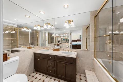 a bathroom with a sink vanity granite tub and shower