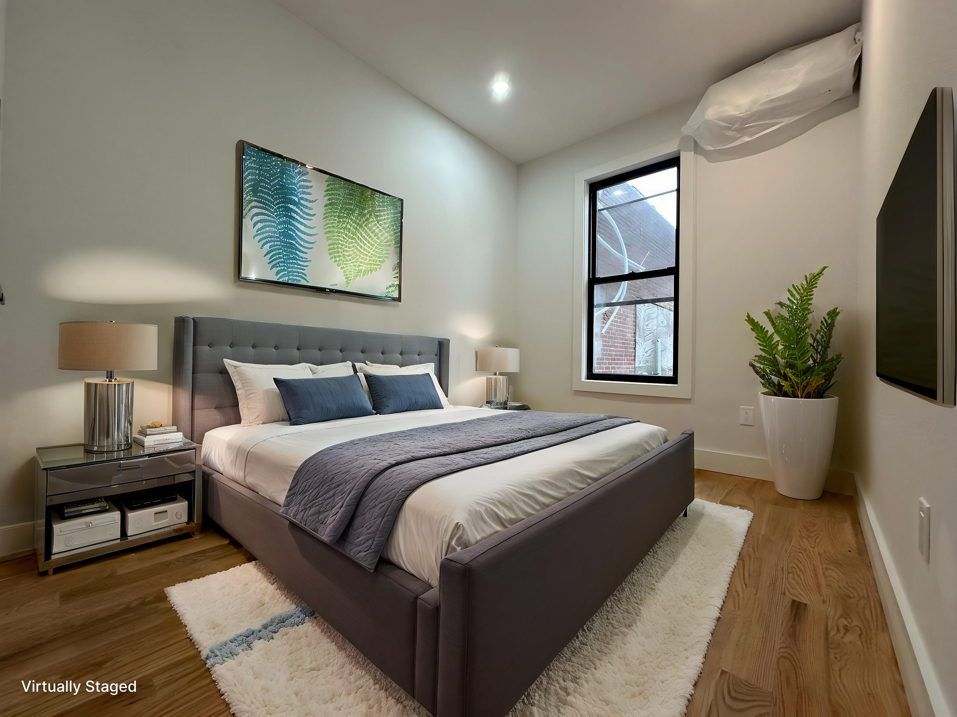 38-18 32nd Street, Unit 1 Queens, NY 11101 - Photo 3 of 6 a bedroom with bed and a potted plant