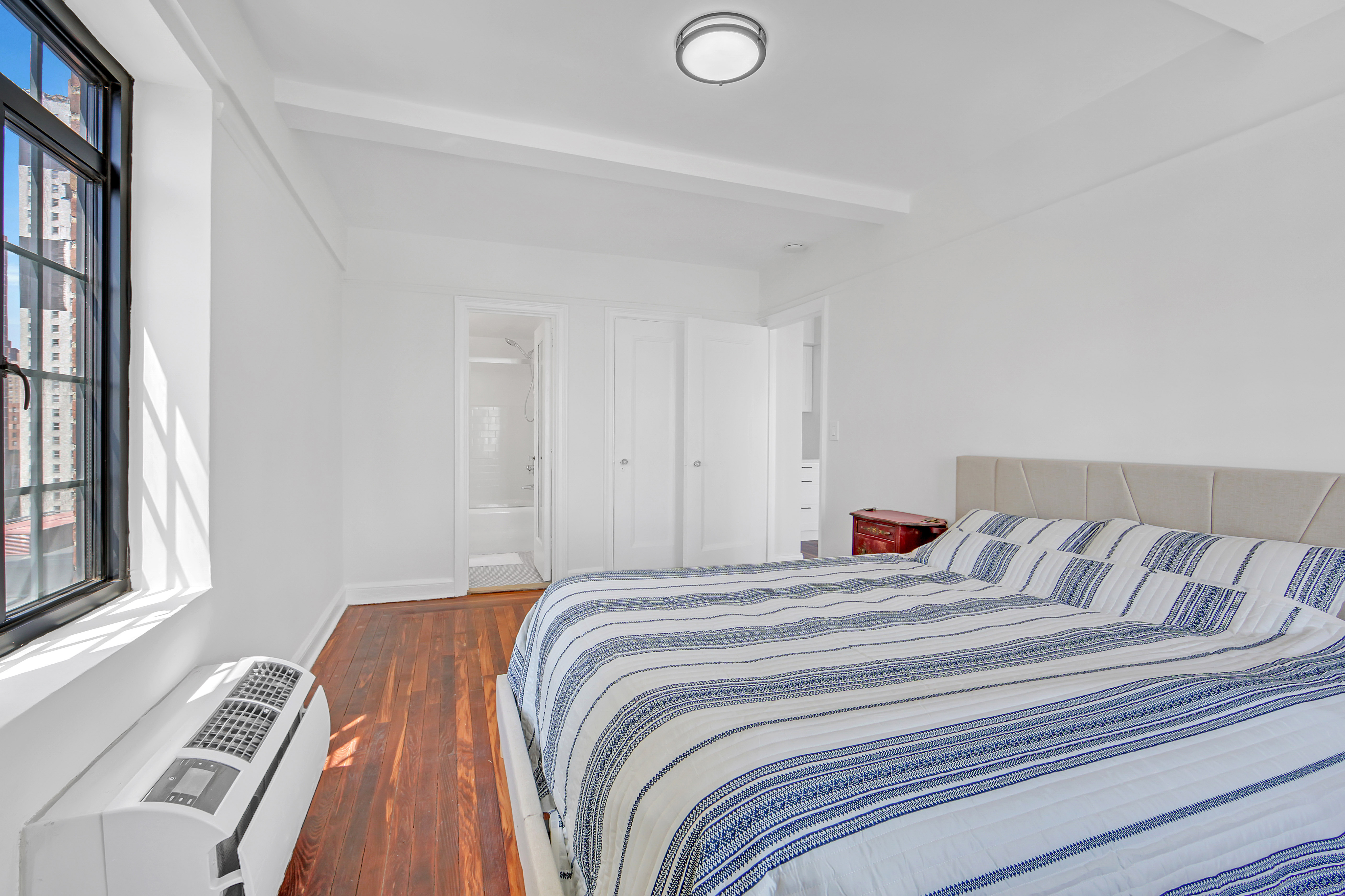 5 Tudor City Place, Unit 625 Manhattan, NY 10017 - Photo 7 of 11 a bedroom with a bed and a window