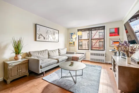 a living room with furniture a flat screen tv and a large window