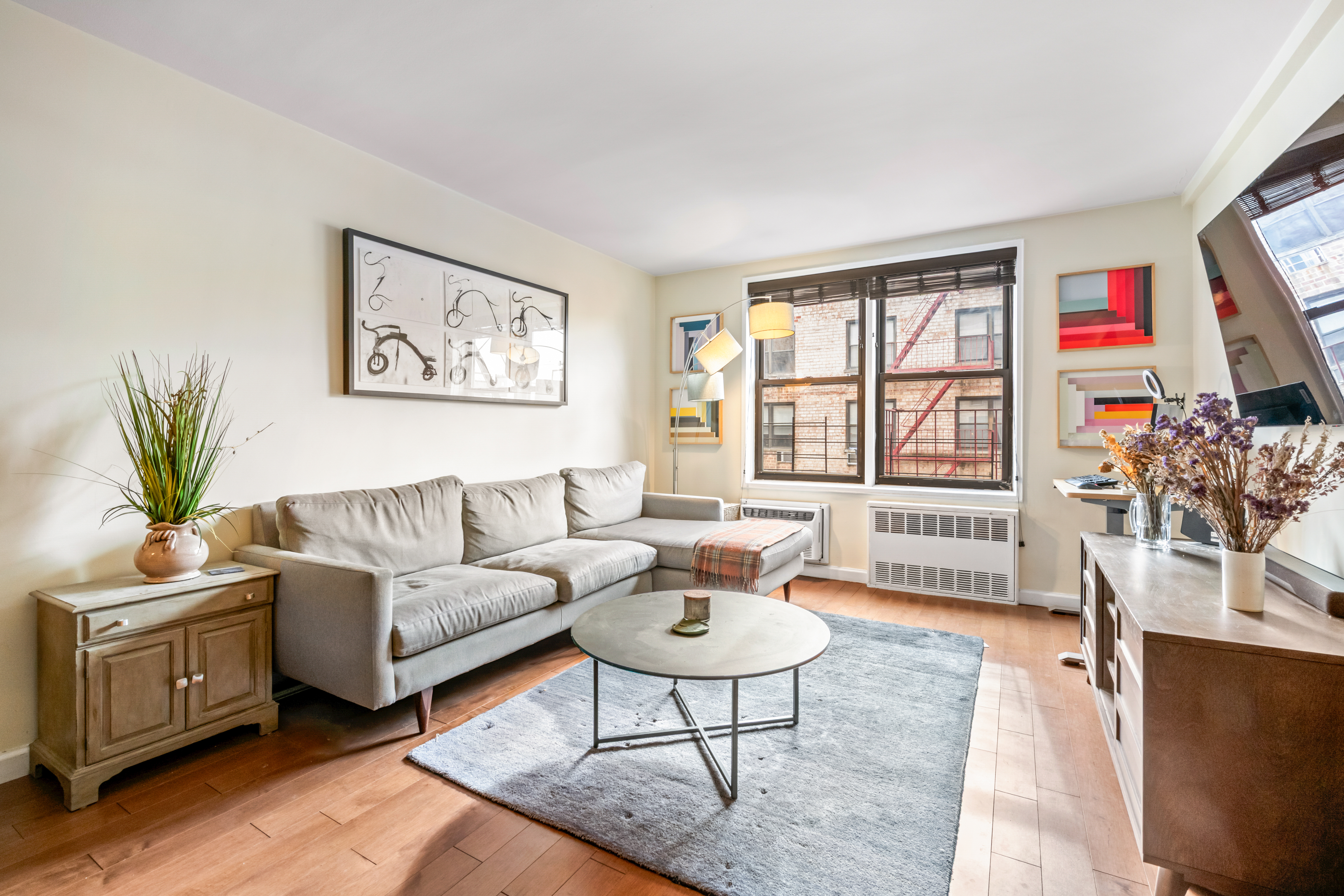 a living room with furniture a flat screen tv and a large window